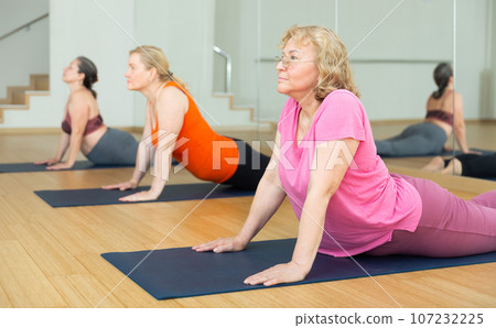 Active senior woman practicing yoga at group 107232225