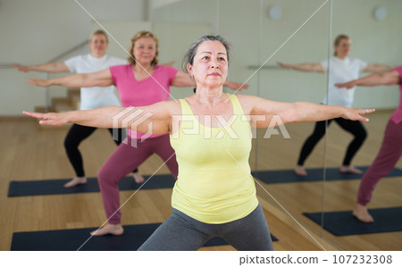 Aged women are exercising warrior II pose Aged women are exercising warrior II pose 107232308