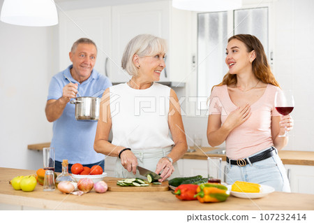 Happy smiling parents enjoy weekend cook with daughter Happy smiling parents enjoy weekend cook with daughter 107232414