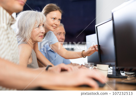 Female teacher helps an elderly woman learn how to use computer in nursing home Female teacher helps an elderly woman learn how to use computer in nursing home 107232513