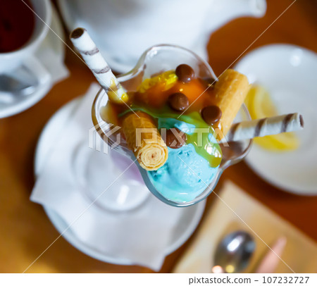 Dessert of two scoops of ice cream, waffle and chocolate candy Dessert of two scoops of ice cream, waffle and chocolate candy 107232727