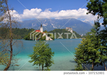 Lake Bled in Slovenia, Southern Europe - Church of the Assumption of the Virgin Mary on Bled Island, Bled Castle and the Julian Alps floating on the surface of the lake 107232801