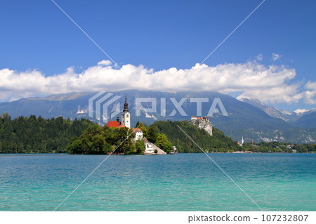 Lake Bled in Slovenia, Southern Europe - Church of the Assumption of the Virgin Mary on Bled Island, Bled Castle and the Julian Alps floating on the surface of the lake 107232807