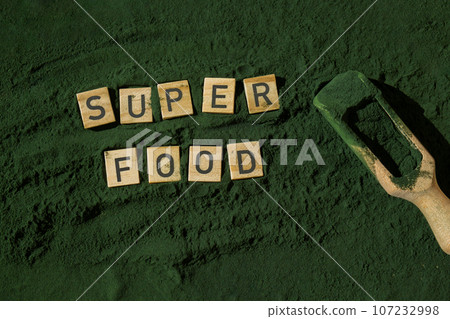 Wooden blocks with text SUPERFOOD chlorella on background of algae superfood powder. Healthy benefits supplement and vegan antioxidant healthy eating Wooden blocks with text SUPERFOOD chlorella on background of algae superfood powder. Healthy benefits supplement and vegan antioxidant healthy eating 107232998