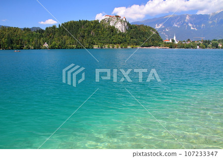 Lake Bled in Slovenia, Southern Europe: Bled Castle and the Julian Alps built on the cliffs of the turquoise lakeshore 107233347