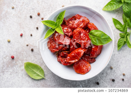 Bowl with sun dried tomatoes with fresh herbs and spices. Bowl with sun dried tomatoes with fresh herbs and spices. 107234869