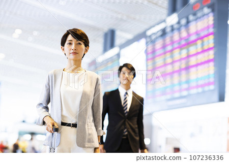 Young male and female businessmen going on a business trip from the airport 107236336