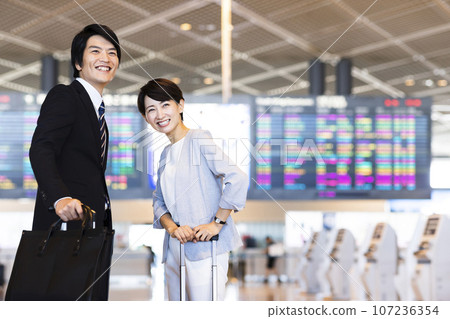 Young male and female businessmen going on a business trip from the airport Young male and female businessmen going on a business trip from the airport 107236354