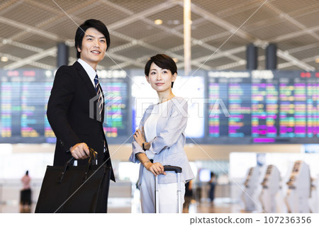 Young male and female businessmen going on a business trip from the airport Young male and female businessmen going on a business trip from the airport 107236356