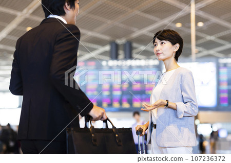 Young male and female businessmen going on a business trip from the airport 107236372