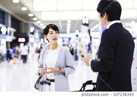 Young male and female businessmen going on a business trip from the airport 107236383