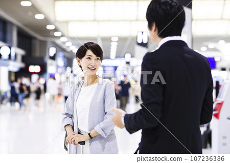 Young male and female businessmen going on a business trip from the airport Young male and female businessmen going on a business trip from the airport 107236386
