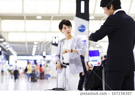 Young male and female businessmen going on a business trip from the airport 107236387