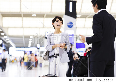 Young male and female businessmen going on a business trip from the airport 107236388