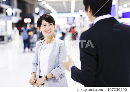 Young male and female businessmen going on a business trip from the airport 107236390