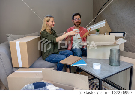 Two people looking busy while packing the boxes for relocation 107236999