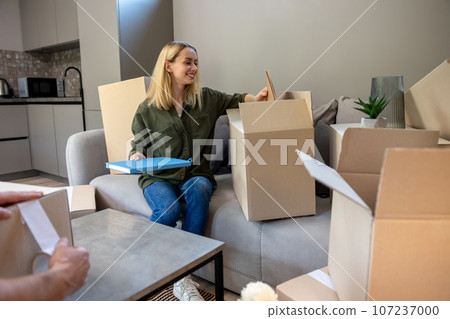 Two people looking busy while packing the boxes for relocation Two people looking busy while packing the boxes for relocation 107237000