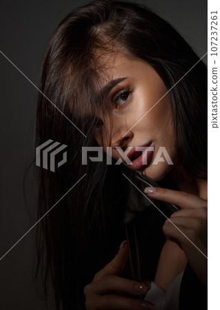 beautiful woman holding eyelashes tweezers on black background beautiful woman holding eyelashes tweezers on black background 107237261