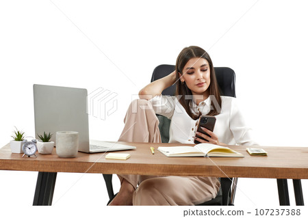 beautiful businesswoman in beige shirt using mobile phone 107237388