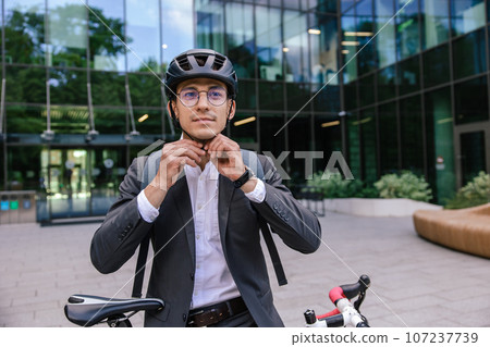Young businessman wearing protective hemlet before cycling 107237739