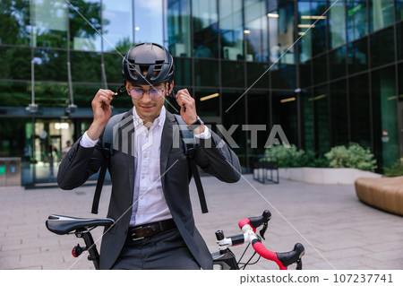 Young businessman wearing protective hemlet before cycling 107237741