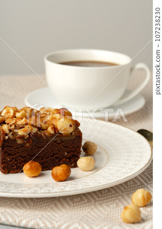 Brownie cake with nuts topping on plate close up Brownie cake with nuts topping on plate close up 107238230
