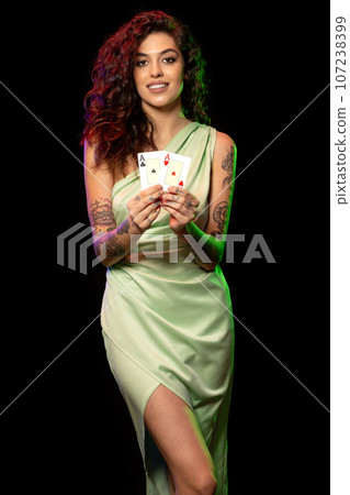 Happy young brunette demonstrating set of winning pair of aces 107238399