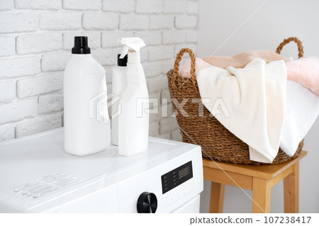 Detergent bottle on washing machine in a laundry room 107238417