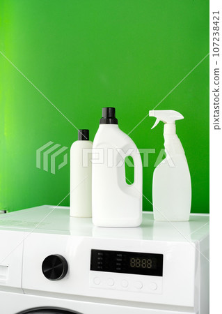 Detergent bottle on washing machine in a laundry room 107238421