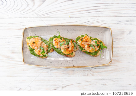 Bruschetta with shrimp on ciabatta toast with avocado cream 107238639