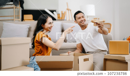 Happy asian young attractive couple man and woman with big boxes moving into a new house, new apartment for couple the new home, Moving house. 107238786