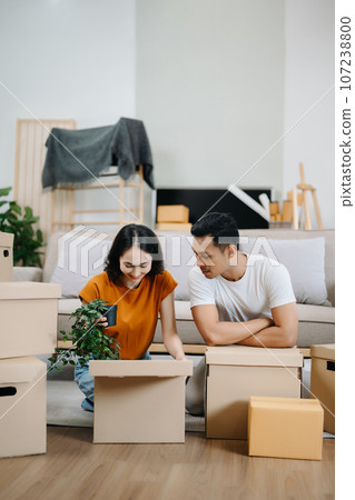 Young couple with big boxes moving into a new house, new apartment for couple, young asian man and woman helping to lift boxes on sofa for the new home, Moving house.. 107238800