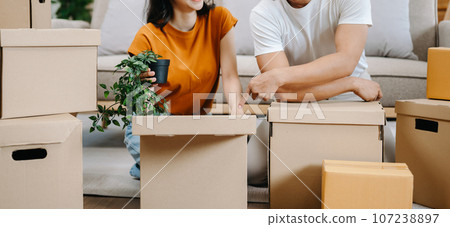 Happy asian young attractive couple man and woman with big boxes moving into a new house, new apartment for couple the new home, Moving house. Happy asian young attractive couple man and woman with big boxes moving into a new house, new apartment for couple the new home, Moving house. 107238897