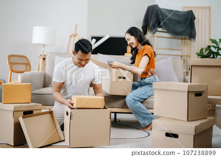 Happy asian young attractive couple man and woman with big boxes moving into a new house, new apartment for couple the new home, Moving house. 107238899
