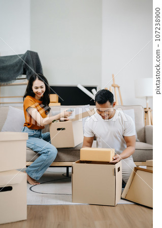 Happy asian young attractive couple man and woman with big boxes moving into a new house, new apartment for couple the new home, Moving house. 107238900