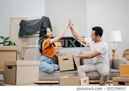 Happy asian young attractive couple man and woman with big boxes moving into a new house, new apartment for couple the new home, Moving house. Happy asian young attractive couple man and woman with big boxes moving into a new house, new apartment for couple the new home, Moving house. 107239041