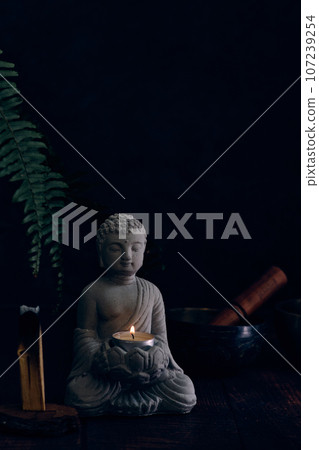stone statue of buddha with a candle stone statue of buddha with a candle 107239254