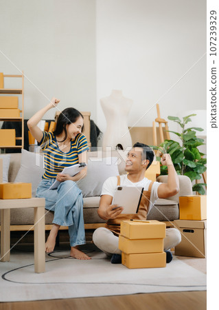 Starting small businesses SME owners, two check online orders Selling products working with boxs freelance work at home office using tablet and laptop  marketing, packaging, concept 107239329