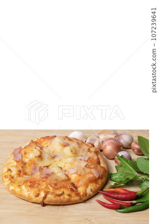 Pizza with fresh chili and garlic along with basil on wooden table Pizza with fresh chili and garlic along with basil on wooden table 107239641