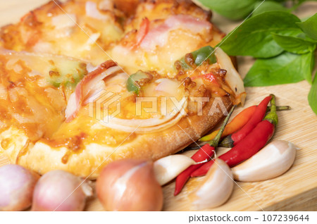 Pizza background in fast food close up with fresh paprika, garlic, shallots Pizza background in fast food close up with fresh paprika, garlic, shallots 107239644