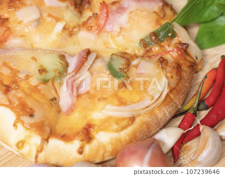 Pizza background in fast food close up with fresh paprika, garlic, shallots Pizza background in fast food close up with fresh paprika, garlic, shallots 107239646
