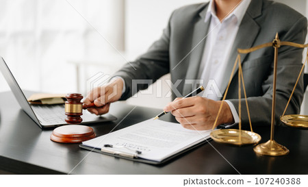 justice and law concept.Male judge in a courtroom on wooden table and Counselor or Male lawyer working in office. . justice and law concept.Male judge in a courtroom on wooden table and Counselor or Male lawyer working in office. . 107240388