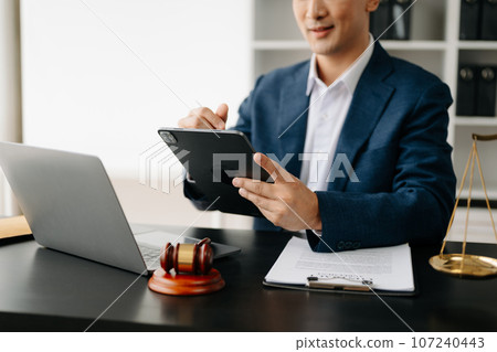 justice and law concept.Male judge in a courtroom on wooden table and Counselor or Male lawyer working in office. . justice and law concept.Male judge in a courtroom on wooden table and Counselor or Male lawyer working in office. . 107240443
