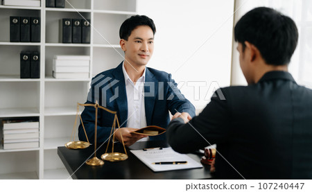 Asian business team and lawyers discussing contract papers sitting at the table. Concepts of law, advice, legal services. at office 107240447