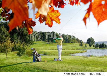 Man playing golf during colorful autumn Man playing golf during colorful autumn 107240613