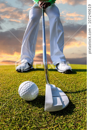 Man playing golf against colorful sunset Man playing golf against colorful sunset 107240619