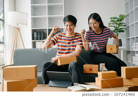 Starting small businesses SME owners, two check online orders Selling products working with boxs freelance work on sofa at home using tablet and laptop marketing, packaging, concept. Starting small businesses SME owners, two check online orders Selling products working with boxs freelance work on sofa at home using tablet and laptop marketing, packaging, concept. 107241460