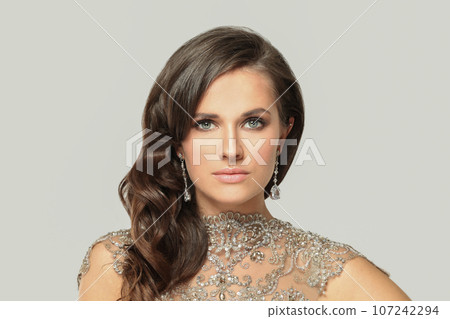 Pretty fashion model woman in diamond jewelry and silver evening gown portrait 107242294