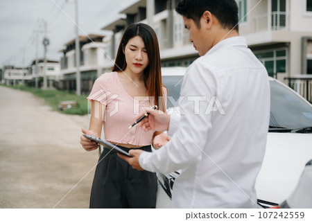 Customers and car insurance agents have entered into agreements and signed documents to claim compensation after on the road in sun light.. 107242559