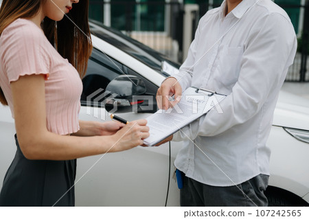 Customers and car insurance agents have entered into agreements and signed documents to claim compensation after on the road in sun light.. 107242565